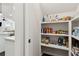 Walk-in pantry with ample shelving for storage, open to a well-lit kitchen and dining area at 871 Dunning St, Marietta, GA 30060