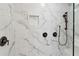 Close up of walk-in shower with marble-look tile, built-in niche, and dual showerheads at 871 Dunning St, Marietta, GA 30060