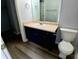 Bathroom features a large vanity with dark cabinets, a white countertop and toilet at 1510 Paramount Ln, Sugar Hill, GA 30518