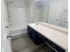 Bathroom vanity with dark cabinets, light countertop, and tub with shower at 1510 Paramount Ln, Sugar Hill, GA 30518