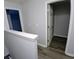 Hallway featuring neutral walls and wood-look floors, with an open door to the closet at 1510 Paramount Ln, Sugar Hill, GA 30518