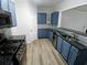 Stylish kitchen with blue cabinets, a stainless steel dishwasher, and a pass-through counter at 1510 Paramount Ln, Sugar Hill, GA 30518