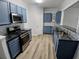 Modern kitchen boasts stainless steel appliances, stylish countertops, and beautiful laminate flooring at 1510 Paramount Ln, Sugar Hill, GA 30518