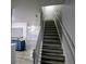 Carpeted staircase with white banister leading to an open-concept kitchen and living area at 1510 Paramount Ln, Sugar Hill, GA 30518