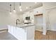 Modern kitchen featuring a granite island, stainless steel microwave, white cabinetry, and stylish pendant lighting at 205 Admor Ln, Acworth, GA 30102