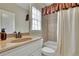 Bathroom with a vanity, shower-tub combo with tiled walls, and a window for natural light at 3060 Salisbury Ln, Cumming, GA 30041