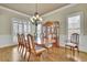 Formal dining room showcasing hardwood floors, plantation shutters, a chandelier, and a wooden china cabinet at 3060 Salisbury Ln, Cumming, GA 30041