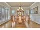 Formal dining room featuring hardwood floors, plantation shutters, a chandelier, and a large mirror at 3060 Salisbury Ln, Cumming, GA 30041