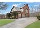 Rear exterior view of a brick home with a two-car garage and a long driveway in a landscaped yard at 3060 Salisbury Ln, Cumming, GA 30041