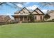 Stunning two-story home featuring a well-manicured lawn, brick and stone accents, and a charming front porch at 3060 Salisbury Ln, Cumming, GA 30041