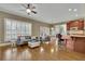 Open-concept living room with hardwood floors, large windows, comfortable seating, and a breakfast bar at 3060 Salisbury Ln, Cumming, GA 30041