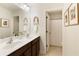 Bathroom featuring double sinks, dark wood cabinets and framed artwork on the walls at 6125 Allison Rd, Cumming, GA 30040