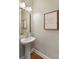 Bathroom featuring pedestal sink, framed mirror and inspiring wall art at 6125 Allison Rd, Cumming, GA 30040