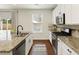 Bright kitchen featuring granite countertops, stainless steel appliances, and hardwood floors at 6125 Allison Rd, Cumming, GA 30040