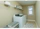 Functional laundry room featuring a washer, dryer, and storage shelves at 6125 Allison Rd, Cumming, GA 30040