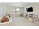Cozy bonus room features neutral tones, window, TV, couch and storage at 6125 Allison Rd, Cumming, GA 30040
