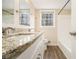 Bright bathroom featuring a granite countertop, dual sinks, and tub with shower at 1731 Fieldgreen Overlook, Stone Mountain, GA 30088