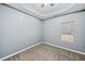 Bedroom features neutral carpet, grey walls, tray ceiling, and window letting in natural light at 279 Scarborough Rd, Stockbridge, GA 30281