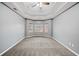 Bedroom with tray ceiling, carpet flooring, and window letting in natural light at 279 Scarborough Rd, Stockbridge, GA 30281