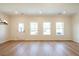 Bright living room featuring hardwood floors, recessed lighting, and three windows overlooking the backyard at 405 Carrera Ln, Acworth, GA 30102