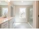 Bright bathroom featuring a glass shower, a stylish vanity, and a sunlit window at 412 Carrera Ln, Acworth, GA 30102