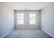 A simple bedroom with gray carpet and two well-lit windows showing an outside view at 412 Carrera Ln, Acworth, GA 30102