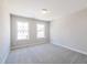 Light-filled bedroom with plush gray carpet and two large windows, creating a serene atmosphere at 412 Carrera Ln, Acworth, GA 30102