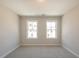 Empty bedroom featuring neutral walls and plush carpeting, with natural light streaming through the windows at 412 Carrera Ln, Acworth, GA 30102
