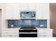 Modern kitchen features white cabinets, stainless steel microwave, and sleek black gas stove at 412 Carrera Ln, Acworth, GA 30102