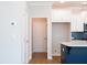 Hallway view into the kitchen showcasing sleek cabinets and a blue kitchen island with a white countertop at 412 Carrera Ln, Acworth, GA 30102