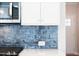 Bright kitchen featuring a blue tile backsplash and stainless steel microwave at 412 Carrera Ln, Acworth, GA 30102
