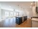 Bright open floor plan features hardwood floors, island with sink and view of the kitchen appliances at 412 Carrera Ln, Acworth, GA 30102