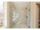 Modern glass shower with herringbone tile and natural light from the window at 412 Carrera Ln, Acworth, GA 30102