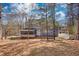 View of the home's backyard, featuring a screened-in porch and a glimpse of the surrounding wooded area at 1230 Scenic Brook Sw Trl, Conyers, GA 30094