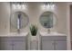 Bathroom featuring dual sinks with modern fixtures, round mirrors, and decorative lights at 1230 Scenic Brook Sw Trl, Conyers, GA 30094