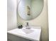 A stylish bathroom with a modern sink, sleek faucet, and round mirror at 1230 Scenic Brook Sw Trl, Conyers, GA 30094