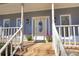 Charming front porch featuring a welcoming entrance with decorative details, complemented by potted plants and stylish exterior lighting at 1230 Scenic Brook Sw Trl, Conyers, GA 30094