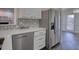 Kitchen featuring stainless steel appliances, white cabinetry, and dining area with ample natural light at 1230 Scenic Brook Sw Trl, Conyers, GA 30094