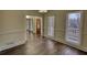 Bright room featuring hardwood floors and large windows providing natural light, enhanced by neutral wall paint at 1230 Scenic Brook Sw Trl, Conyers, GA 30094