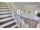 Bright living room with modern flooring, a staircase, and large windows creating an inviting and airy atmosphere at 1230 Scenic Brook Sw Trl, Conyers, GA 30094