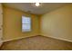 A simple bedroom features neutral carpeting, yellow walls, and white trim and one window at 8138 Brookbend Dr, Douglasville, GA 30134