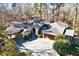 Aerial view of a beautiful home with stone accents, a turret, and a brick driveway surrounded by greenery at 4421 Paradise Cir, Vinings, GA 30339