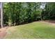 A large, well-maintained lawn surrounded by lush greenery and mature trees offering privacy at 4421 Paradise Cir, Vinings, GA 30339