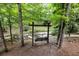 Scenic backyard featuring a wooden swing near a gently flowing creek, nestled among lush trees at 4421 Paradise Cir, Vinings, GA 30339