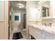 Bathroom with marble vanity, glass enclosed shower and white wainscoting at 4421 Paradise Cir, Vinings, GA 30339