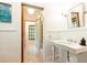This bathroom features a pedestal sink, beadboard paneling, and a view into an adjacent bathroom at 4421 Paradise Cir, Vinings, GA 30339