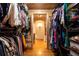 View of a well organized walk-in closet with wood plank ceiling and custom shelving at 4421 Paradise Cir, Vinings, GA 30339
