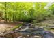 Peaceful creek meandering through a wooded area, creating a serene and natural backyard setting at 4421 Paradise Cir, Vinings, GA 30339