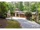Charming stone and siding home with a beautiful turret and a brick driveway amidst lush greenery at 4421 Paradise Cir, Vinings, GA 30339