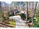 Stunning home features beautiful stone accents, a turret, and a long brick driveway surrounded by trees at 4421 Paradise Cir, Vinings, GA 30339